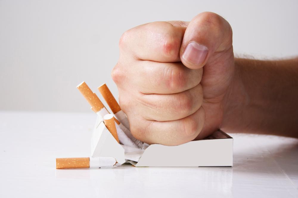 poing écrasant paquet de cigarettes